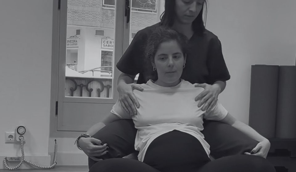 Elena, matrona de A Solas con tu Matrona, y fisioterapeuta de suelo pélvico de Fisioterapia Dalí demuestran una posición de pródromos de parto con apoyo y fitball en Madrid.